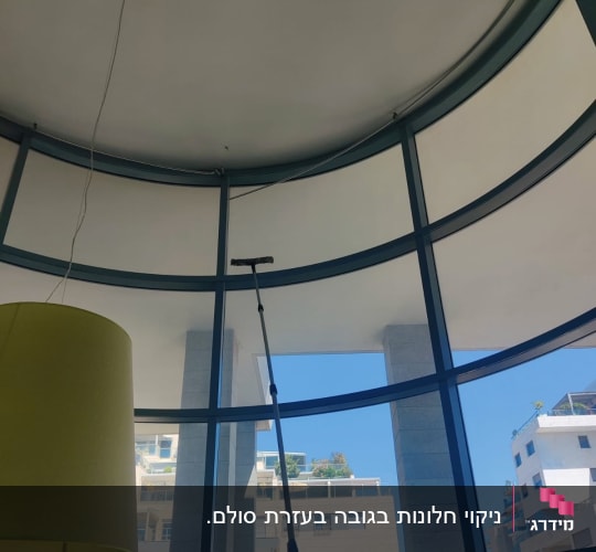 ניקוי חלונות ויטרינה גבוהים בתוך מבנה באמצעות מוט טלסקופי